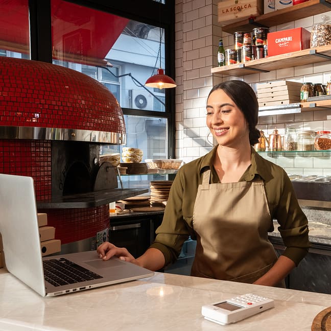 Managing orders on a laptop with a myPOS terminal nearby